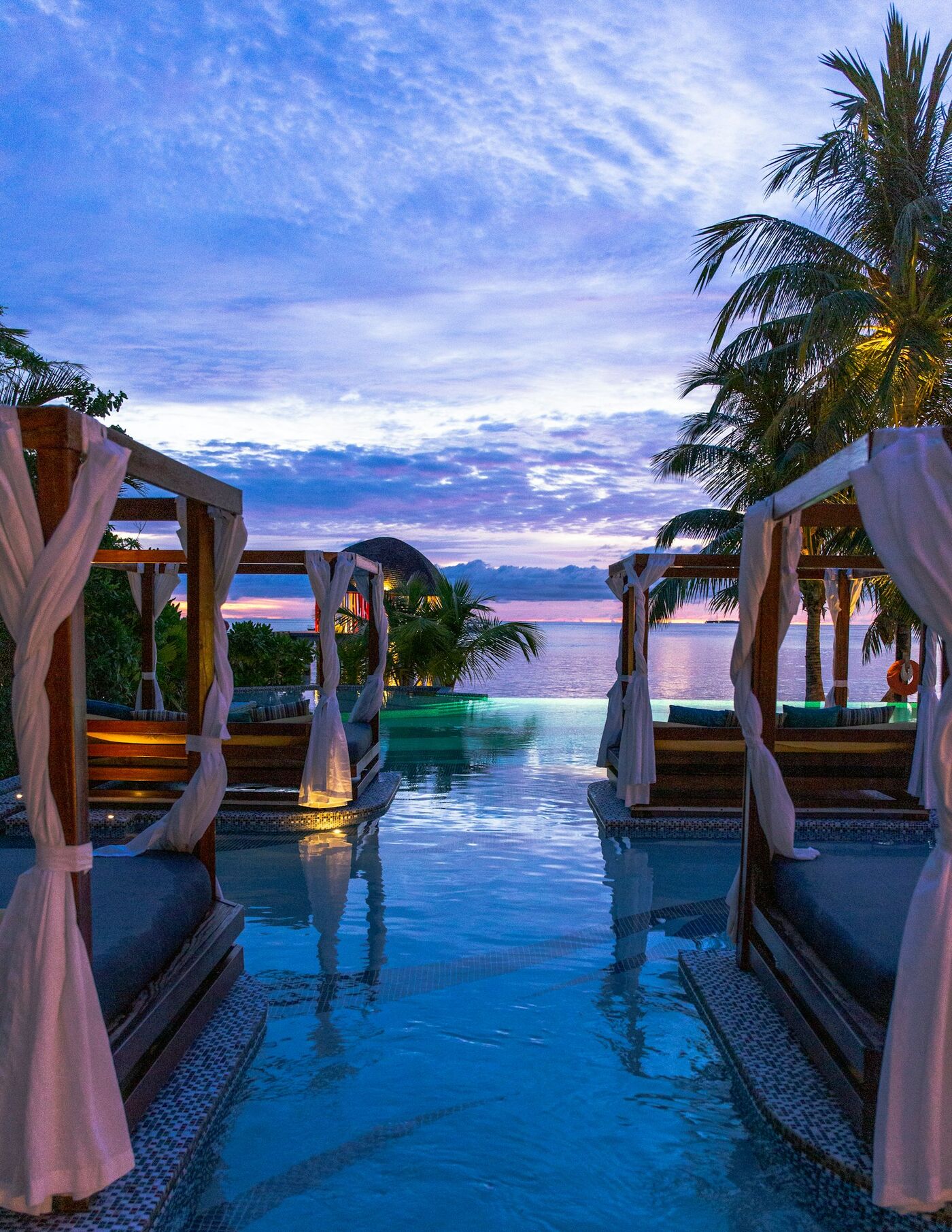 Poolside cabana lounge illuminated at dusk